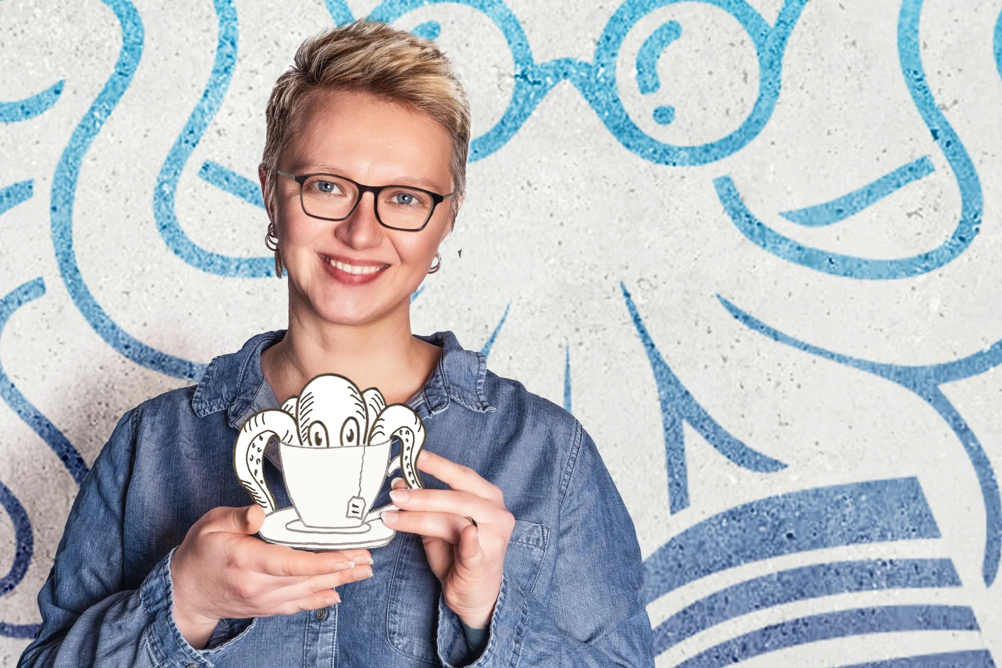 Anna Rachow hält lächelnd eine illustrierte Teetasse, aus der ein Oktopus schaut